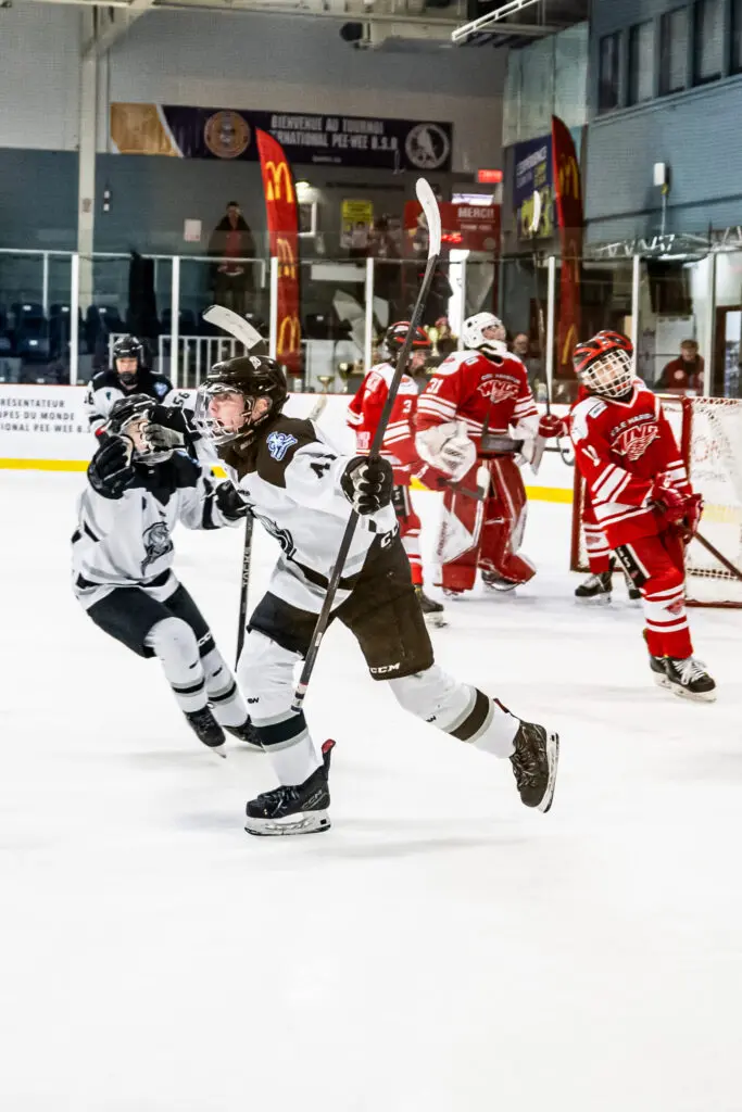 Youth hockey players competing on the ice rink with energy, teamwork, and determination.
