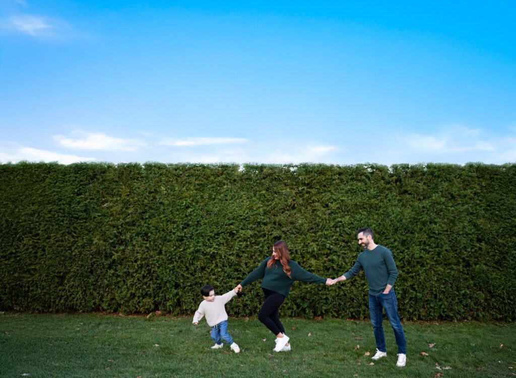 Happy family playing together outdoors on a sunny day in a green field.