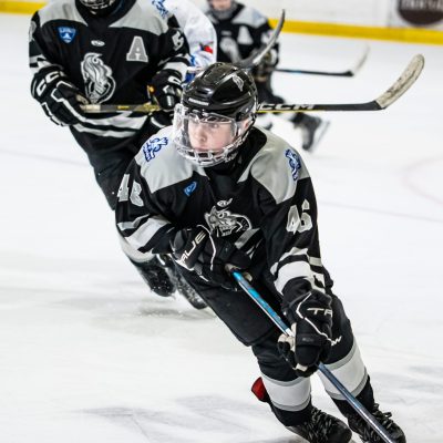 Youth hockey players competing on ice in a fast-paced game filled with energy and action.
